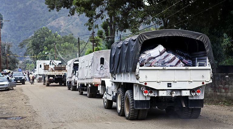 Humanitarian aid trucks driving down a dirt road.