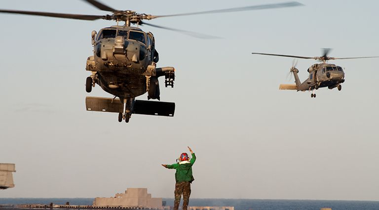 Humanitarian aid helicopters being directed by an air traffic controller on the ground.